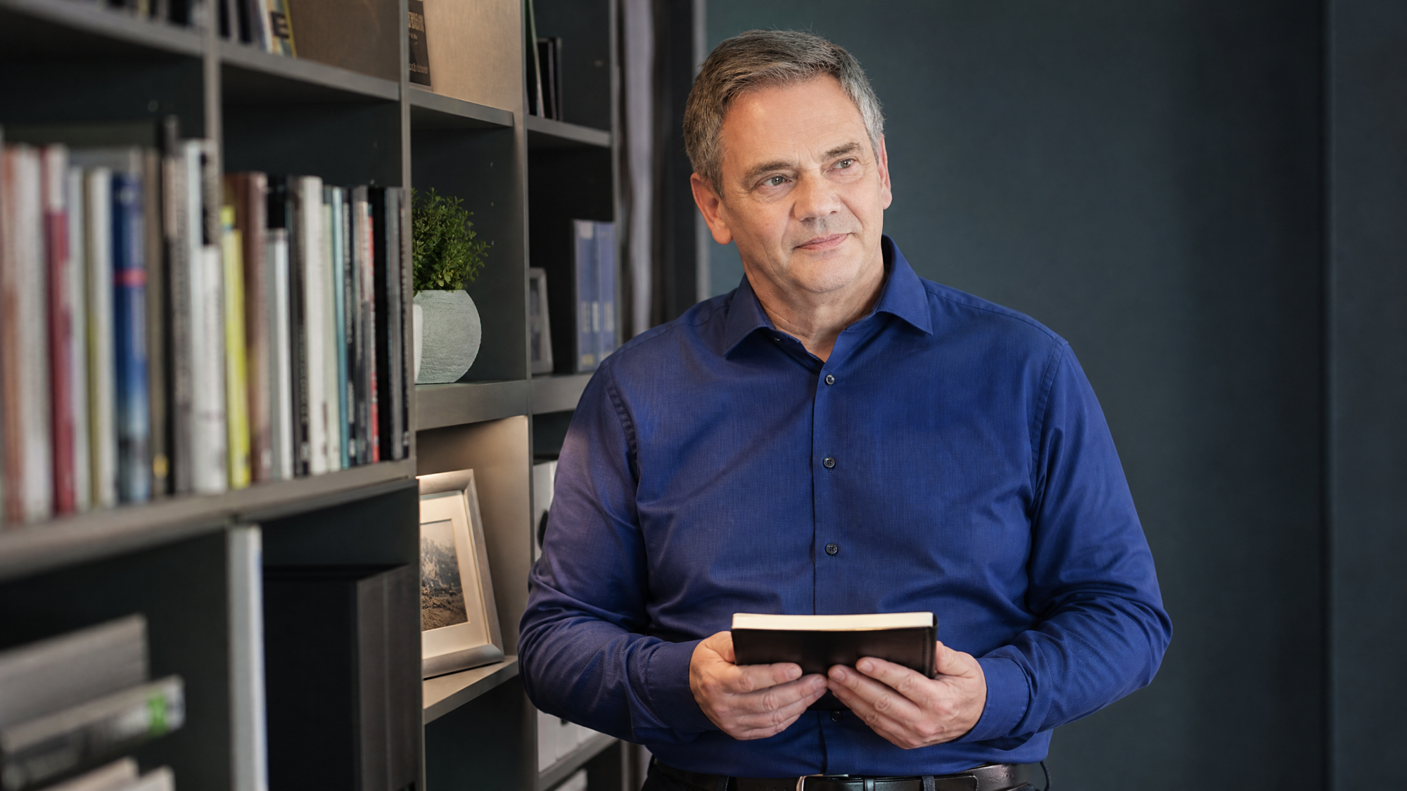 Nachdenklicher Blick am Bücherregal